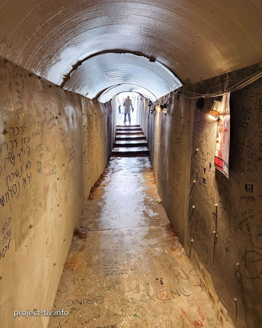 פנים מיצב המנהרה. הקירות מכוסים בכתב ידם של מי שעברו בה, ובקצה אור.